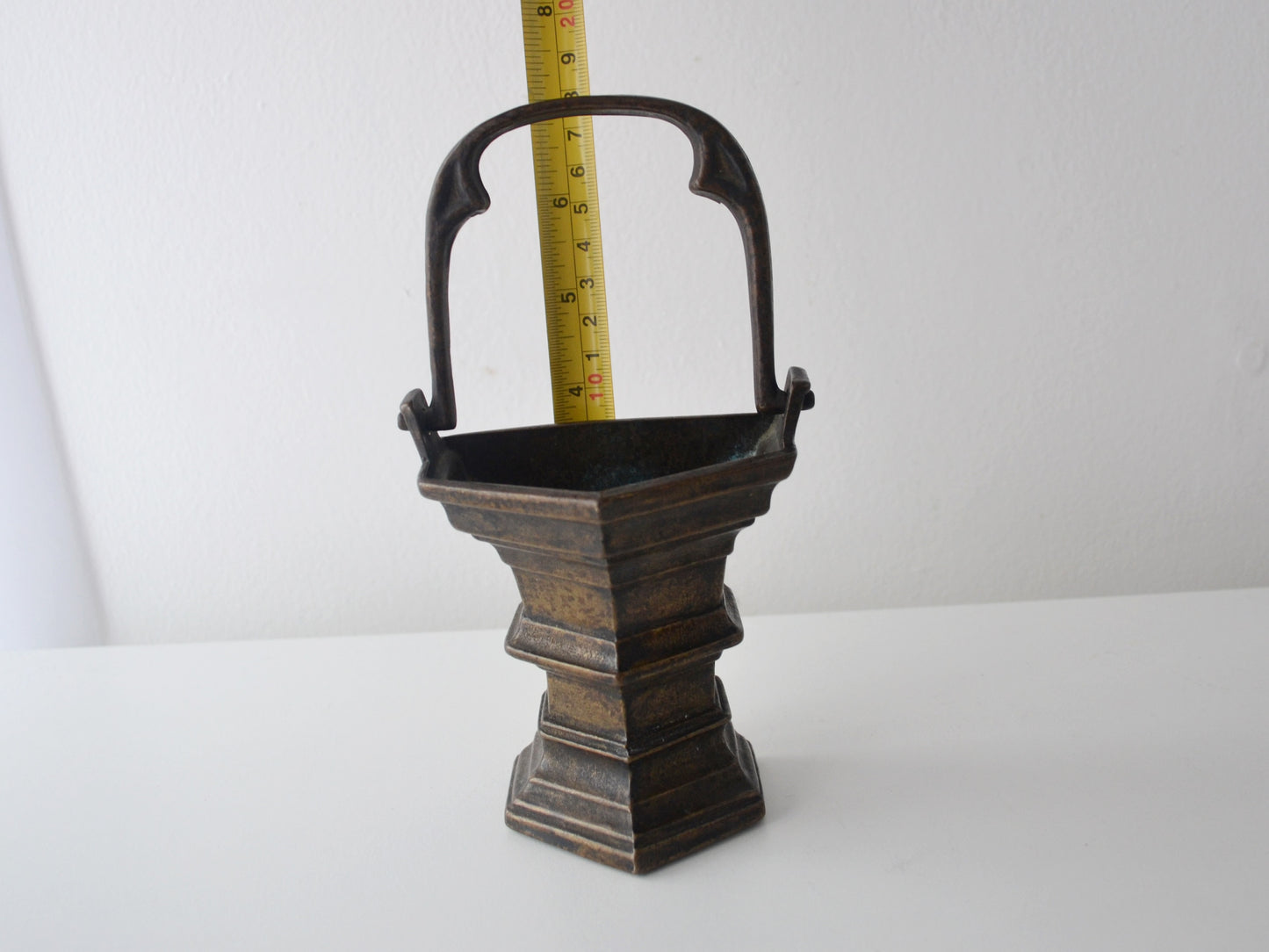 Cast bronze Gothic holy water stoup shown with tape measure, 10cm width, European circa 1900, measurement reference