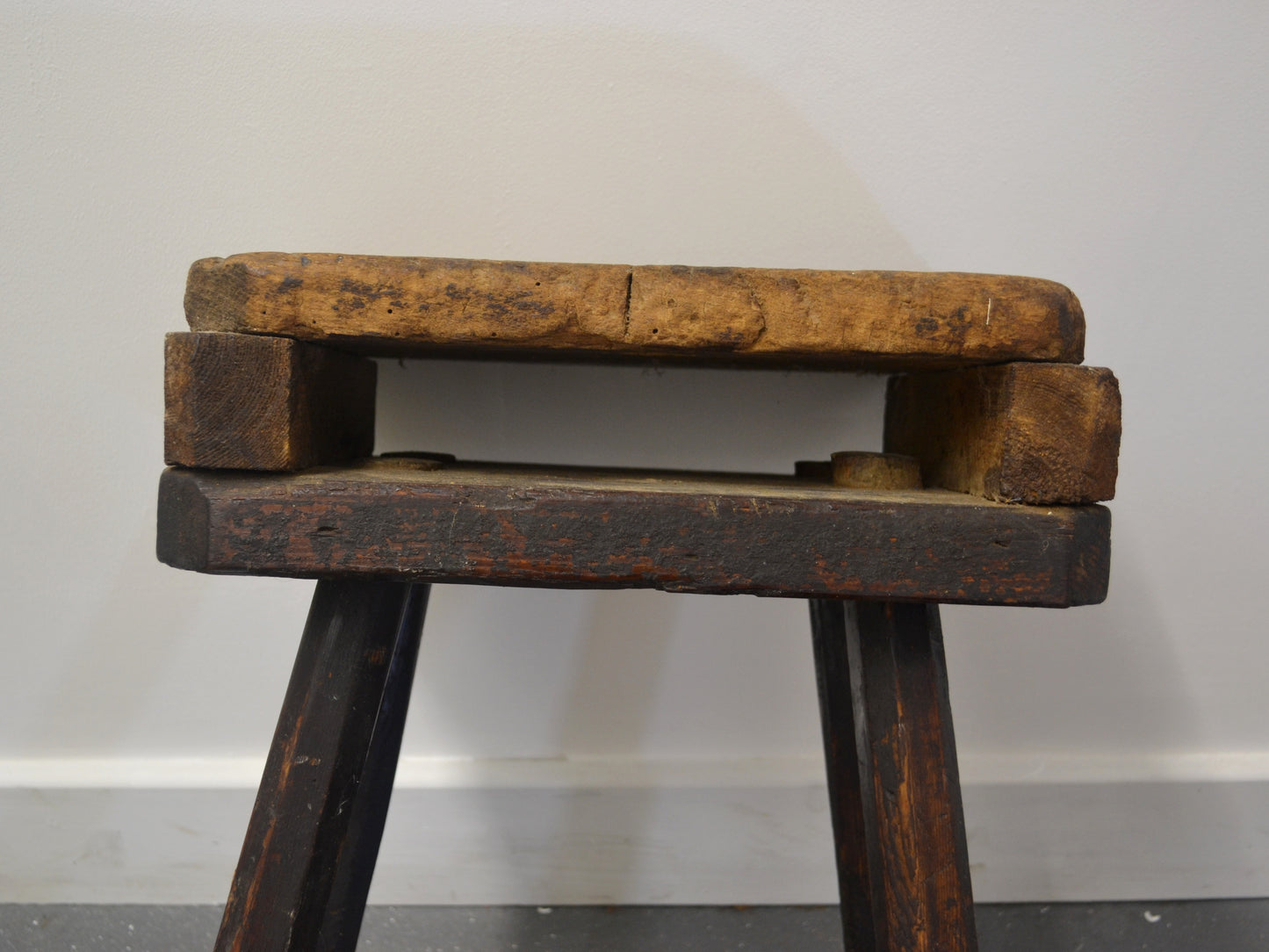 Side profile of antique English cutler's stool showing splayed leg construction and double-top, circa 1880s, workshop furniture