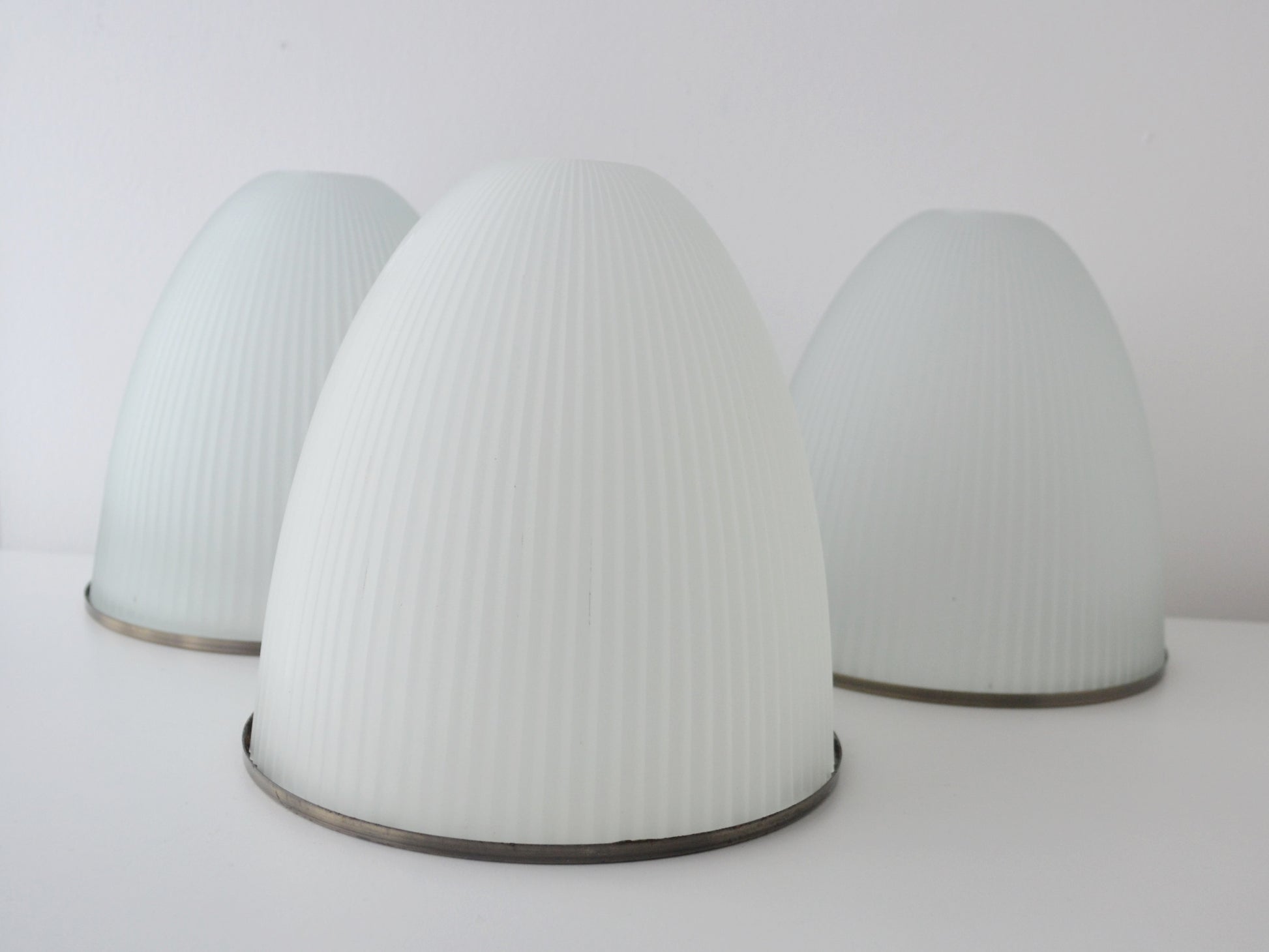 Ribbed milk glass dome pendant shades, Holophane style, mid-century modern, set of three, hero prop lighting, front view