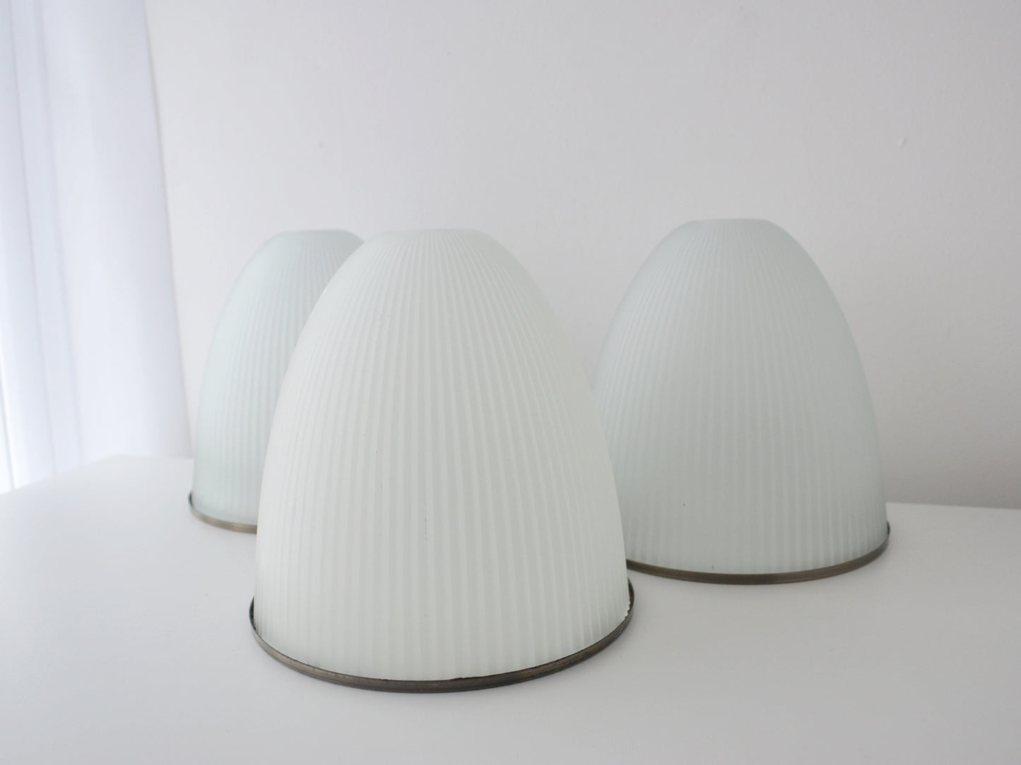 Three ribbed milk glass Holophane style dome shades, mid-century modern, top angle view