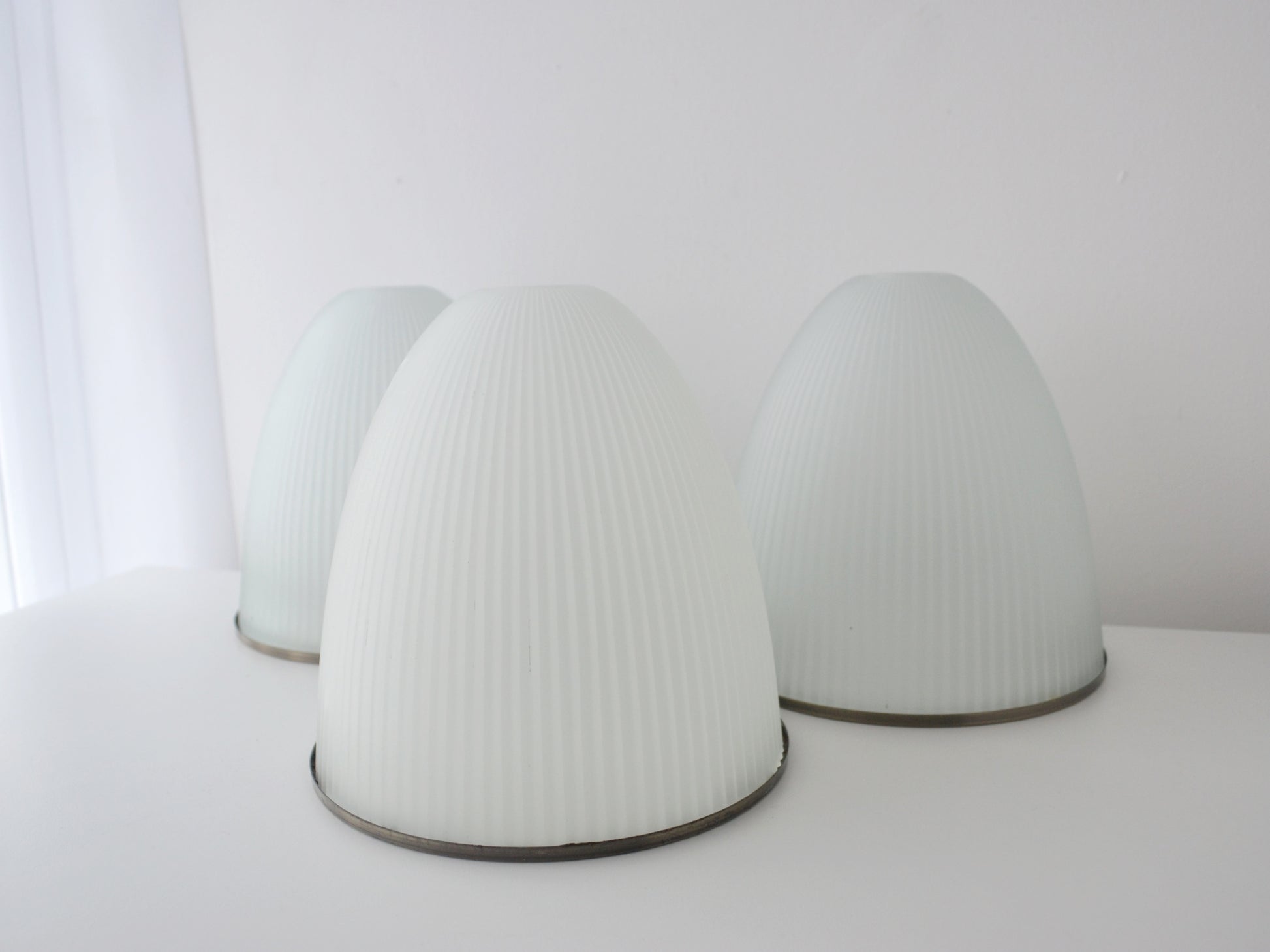 Three ribbed milk glass Holophane style dome shades, mid-century modern, top angle view