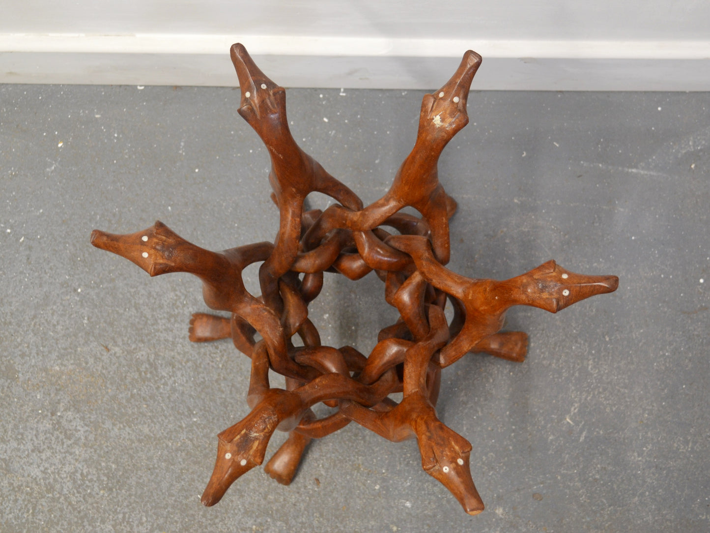 Interlocked chain carving detail of hardwood dog figures stand, bone inlay eyes, circa 1960s.