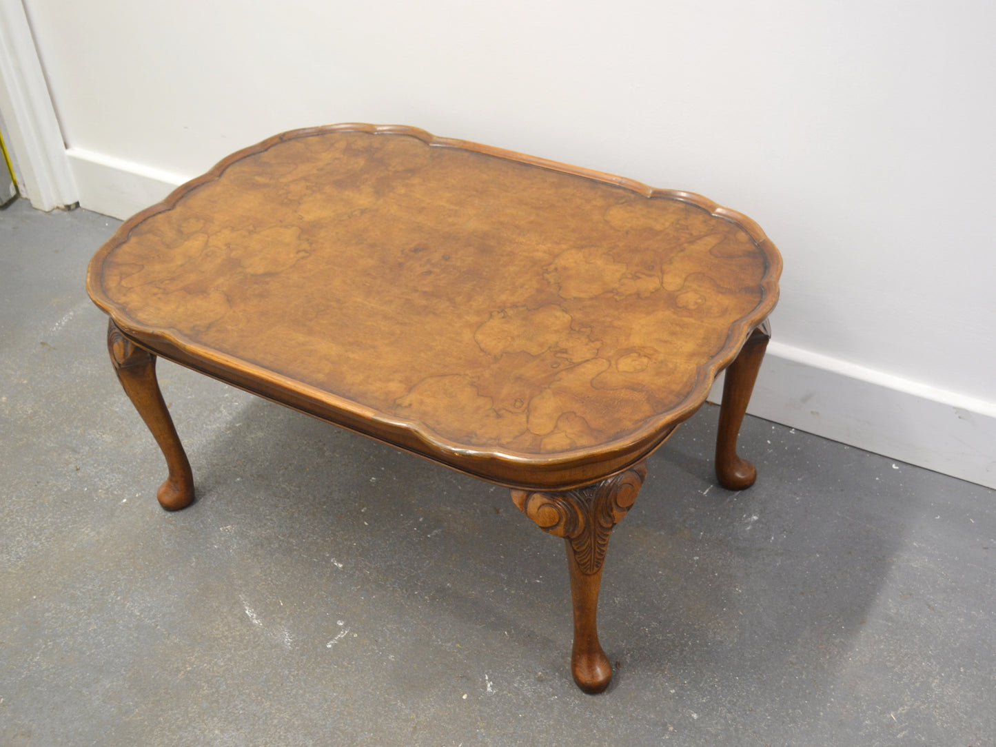 Burr walnut Queen Anne coffee table by Bevan Funnell Reprodux, England circa 1970s, scalloped top, cabriole legs, front view.