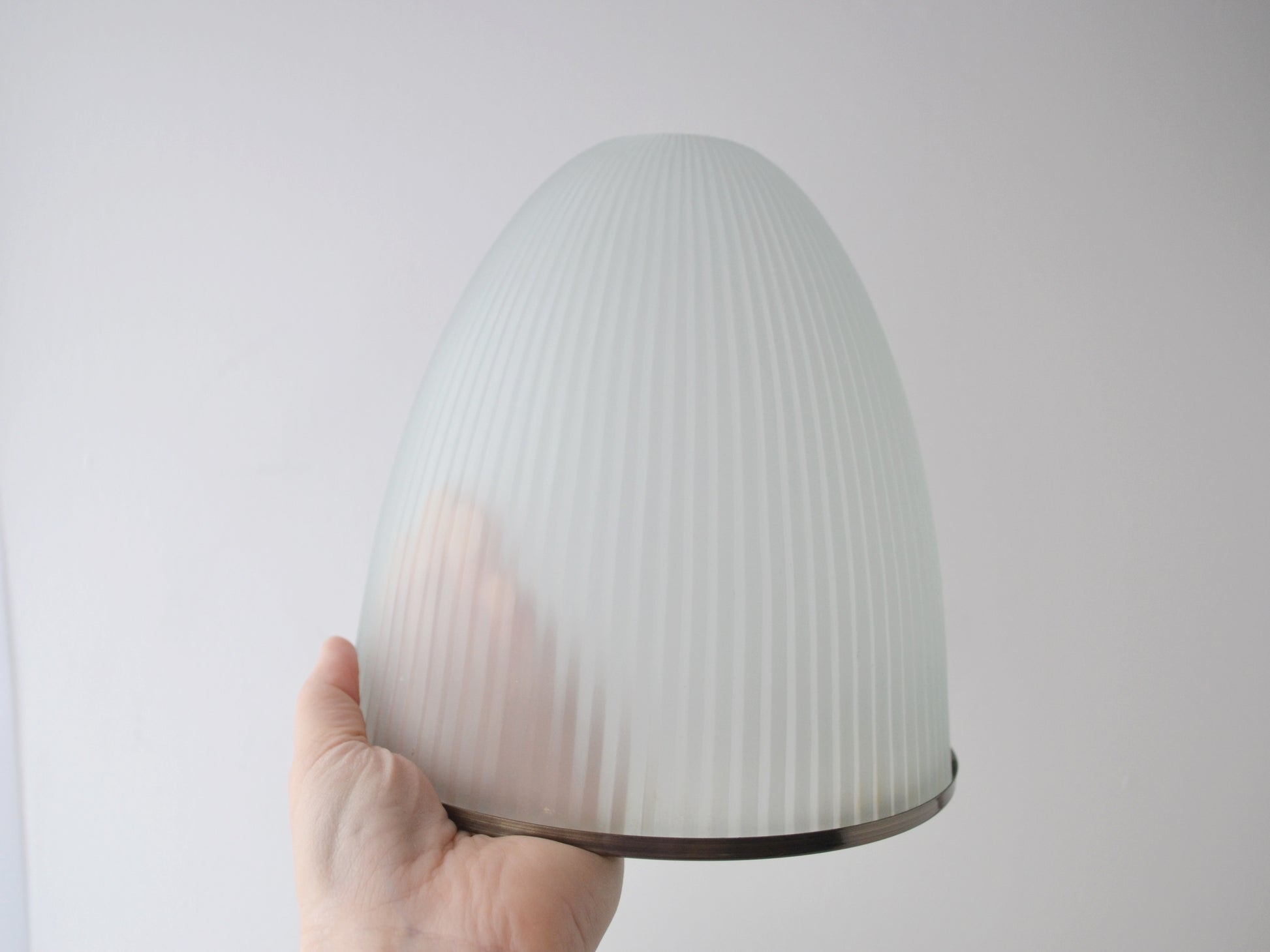 Ribbed milk glass Holophane style dome shade shown with hand for scale, mid-century modern