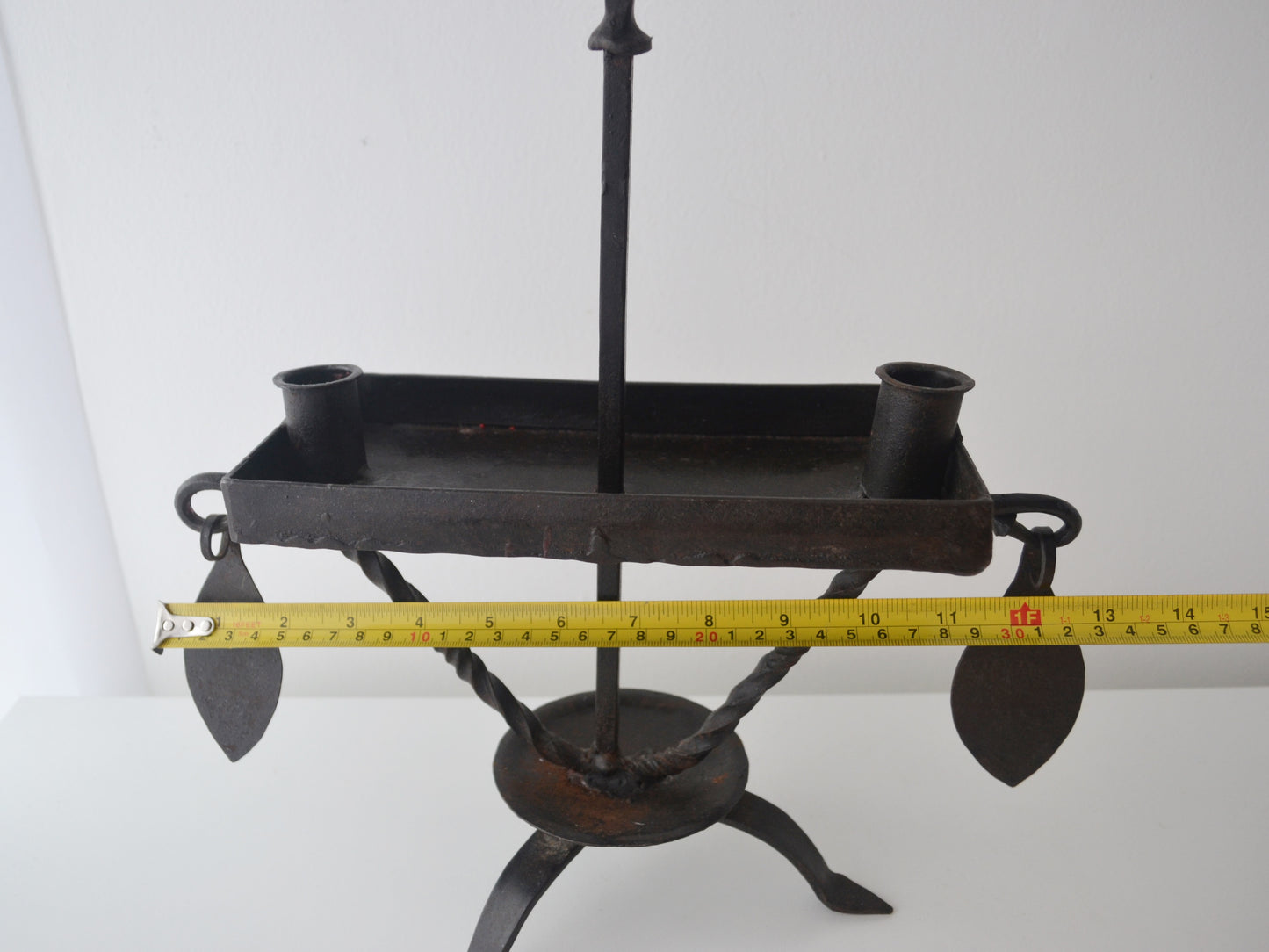 Hand-forged wrought iron candle stand, twisted tripod base and hook finial detail, front view without candles