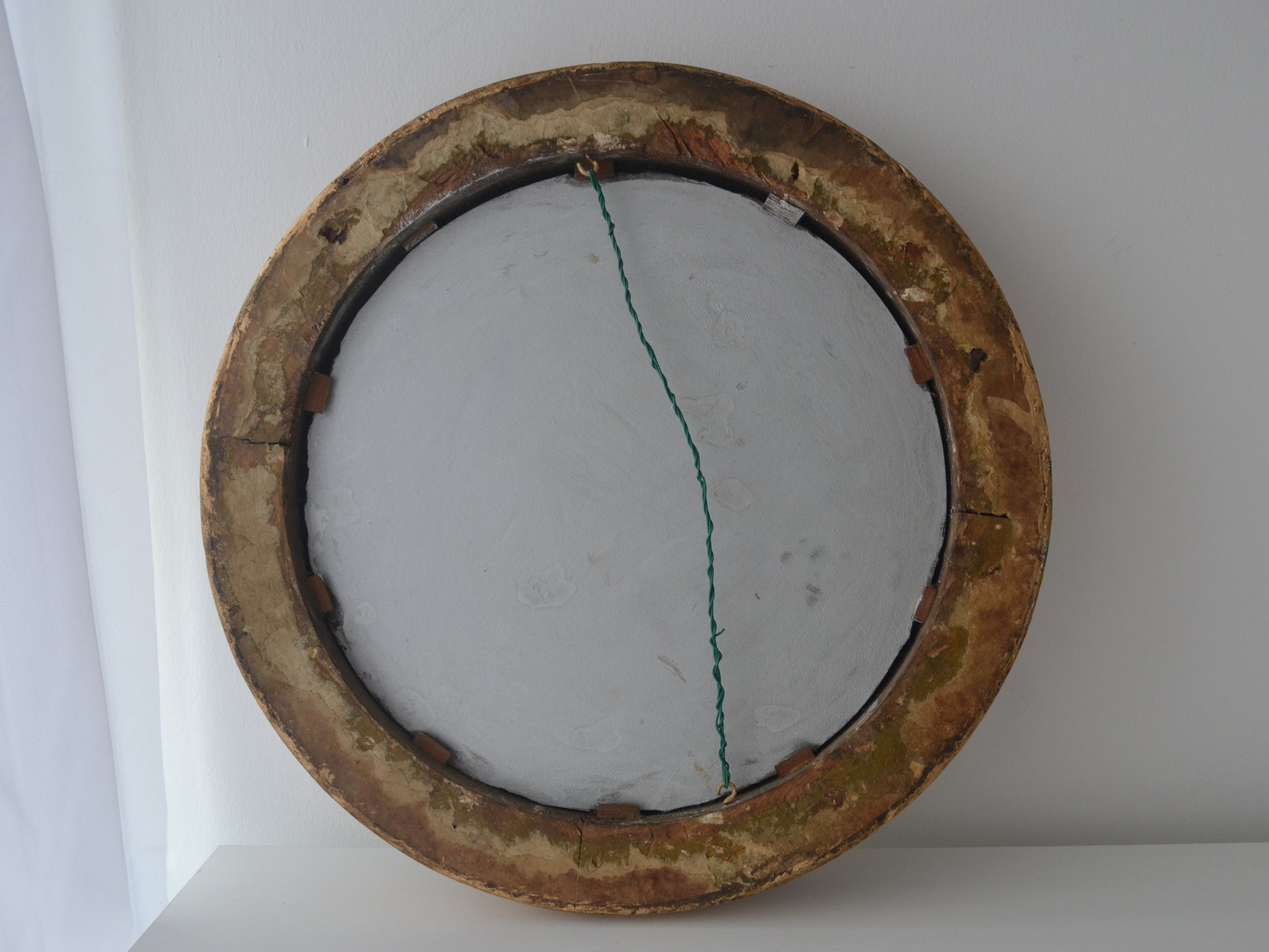 Reverse of antique Victorian gesso barbola round mirror showing original backing and hanging wire England circa 1880