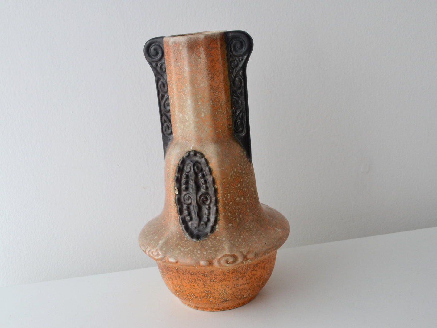 Relief spiral handle detail on Bohemian Art Deco vase, orange and chocolate-brown glaze.