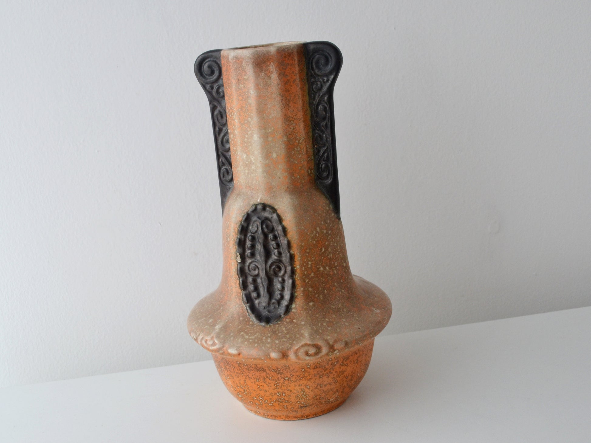 Relief spiral handle detail on Bohemian Art Deco vase, orange and chocolate-brown glaze.