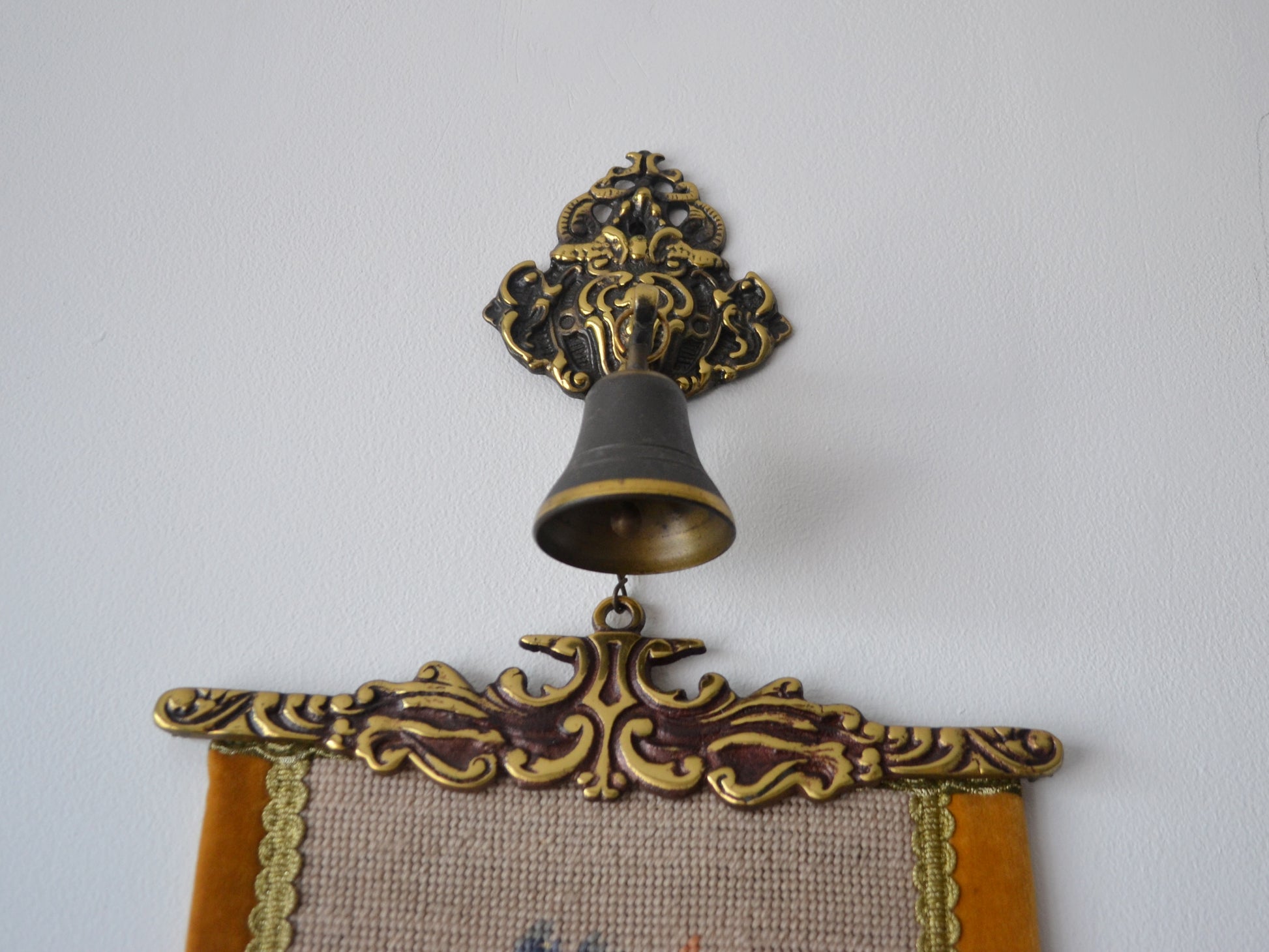 Ornate cast brass upper mount with suspended bell, West German needlepoint bell pull, circa 1950s.