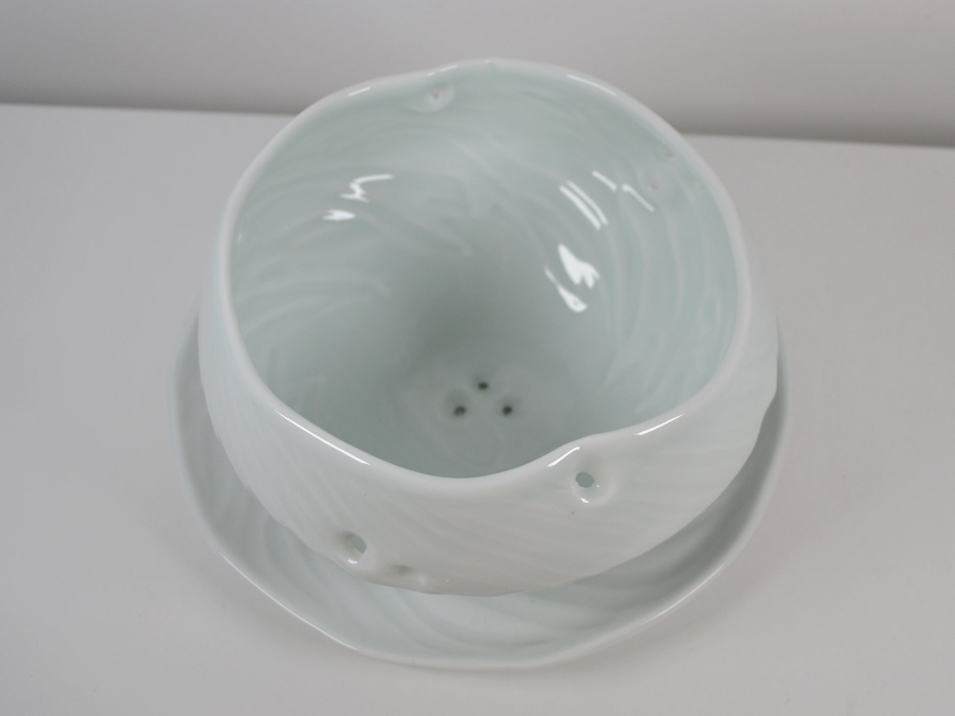 Joanna Howells celadon porcelain berry bowl with drainage holes and matching plate, Wales circa 2000s.