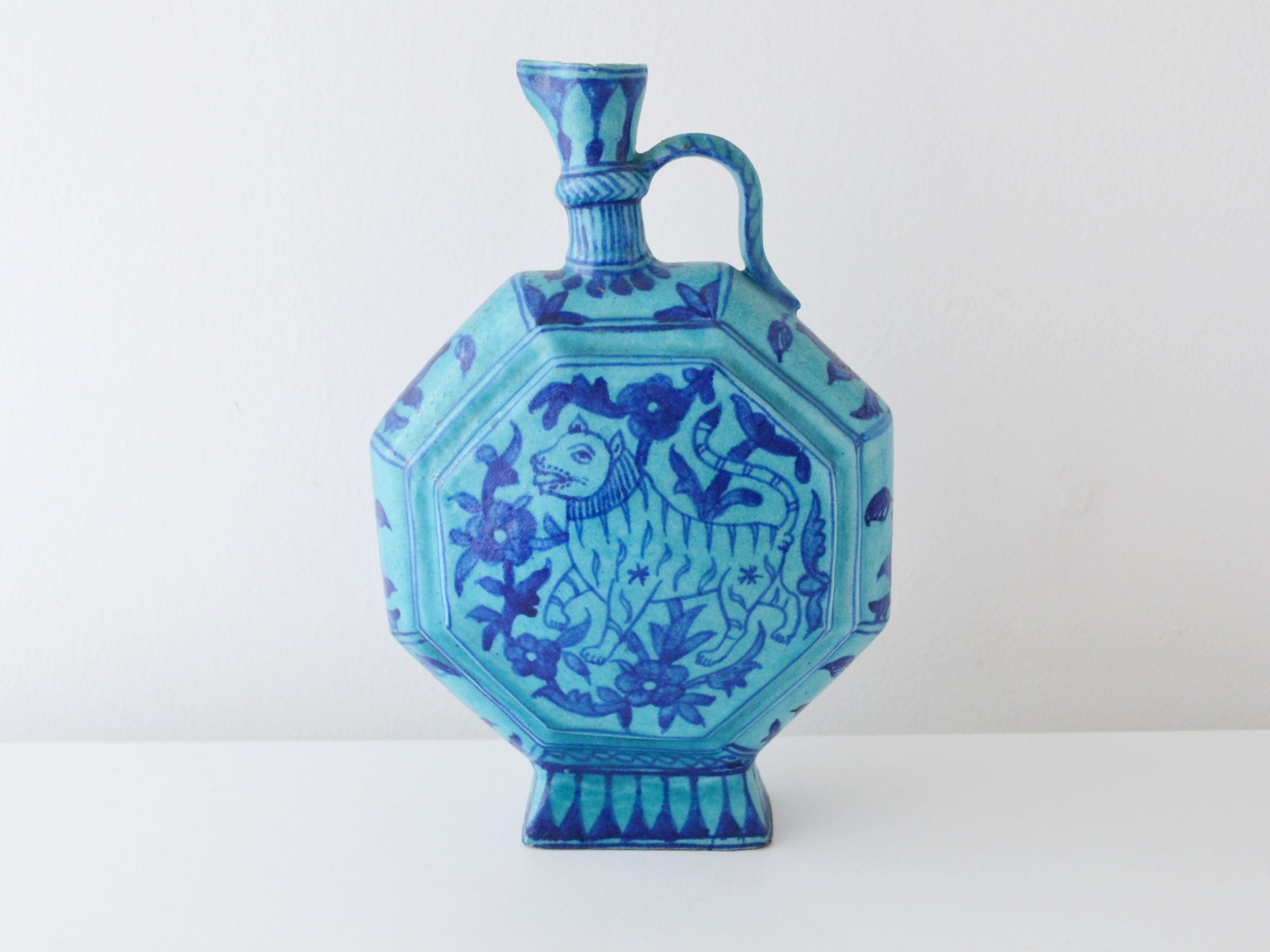 Turquoise Islamic moon flask, Sindh pottery, hand-painted horned animal motif, front view.