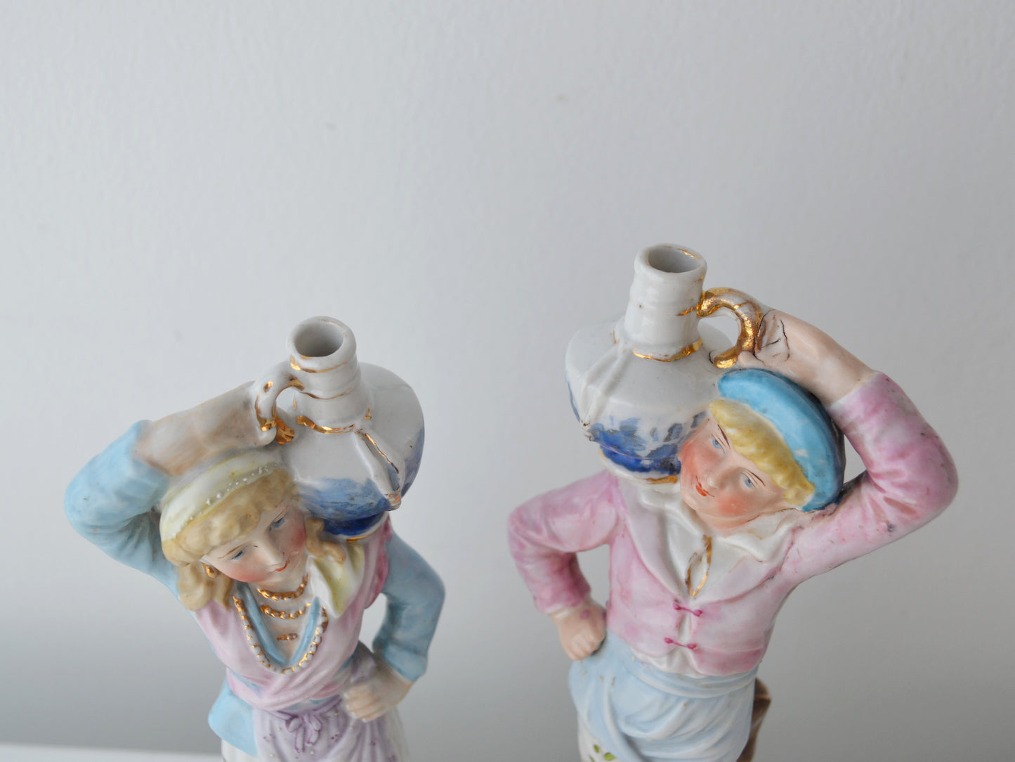 Close-up of gilt blue jugs balanced overhead on Bohemian porcelain water carrier figurines, Elbogen circa 1880s