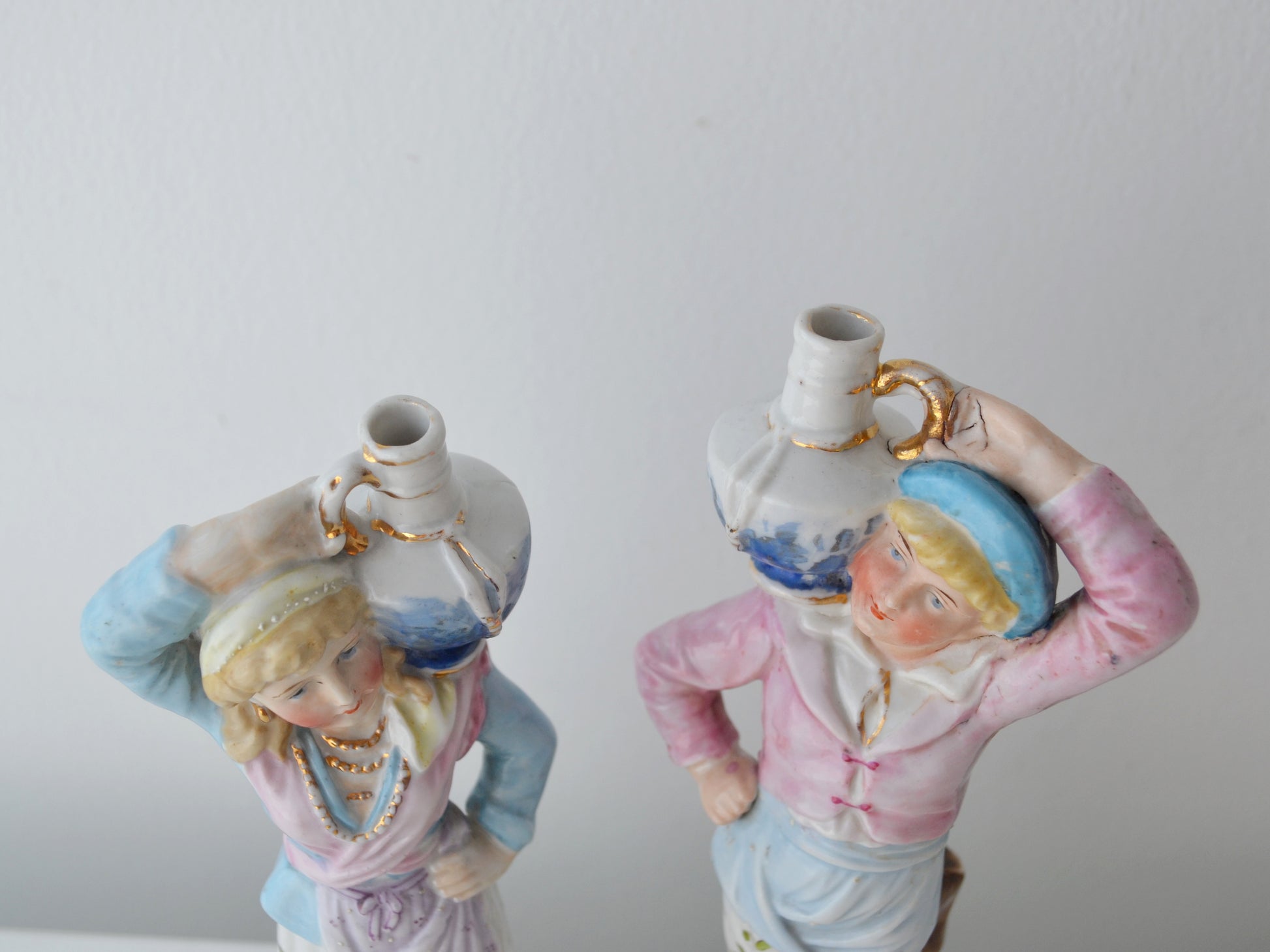 Close-up of gilt blue jugs balanced overhead on Bohemian porcelain water carrier figurines, Elbogen circa 1880s