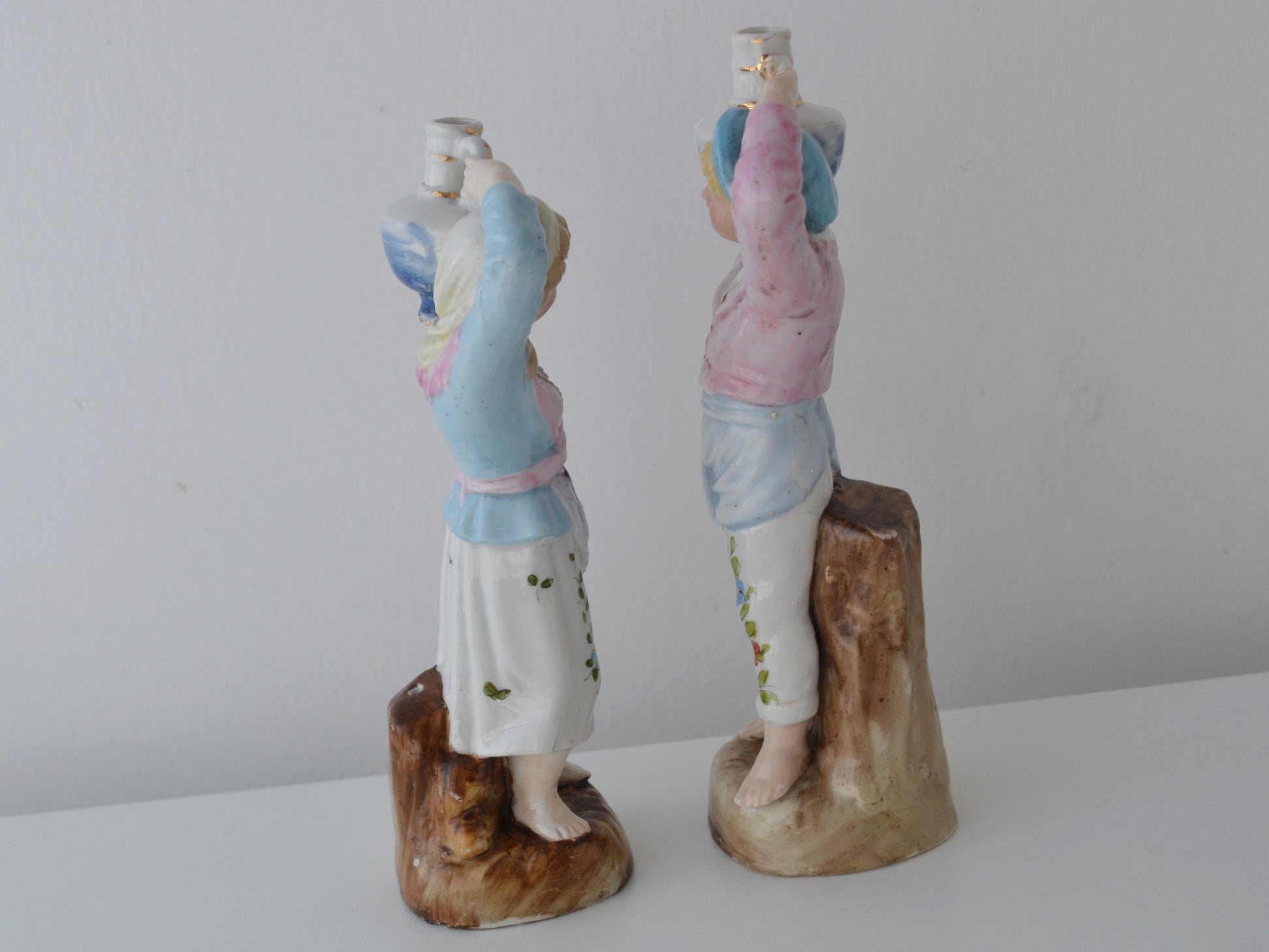 Bohemian porcelain water carrier pair by Elbogen factory, side view showing gilt jug detail and floral costume decoration