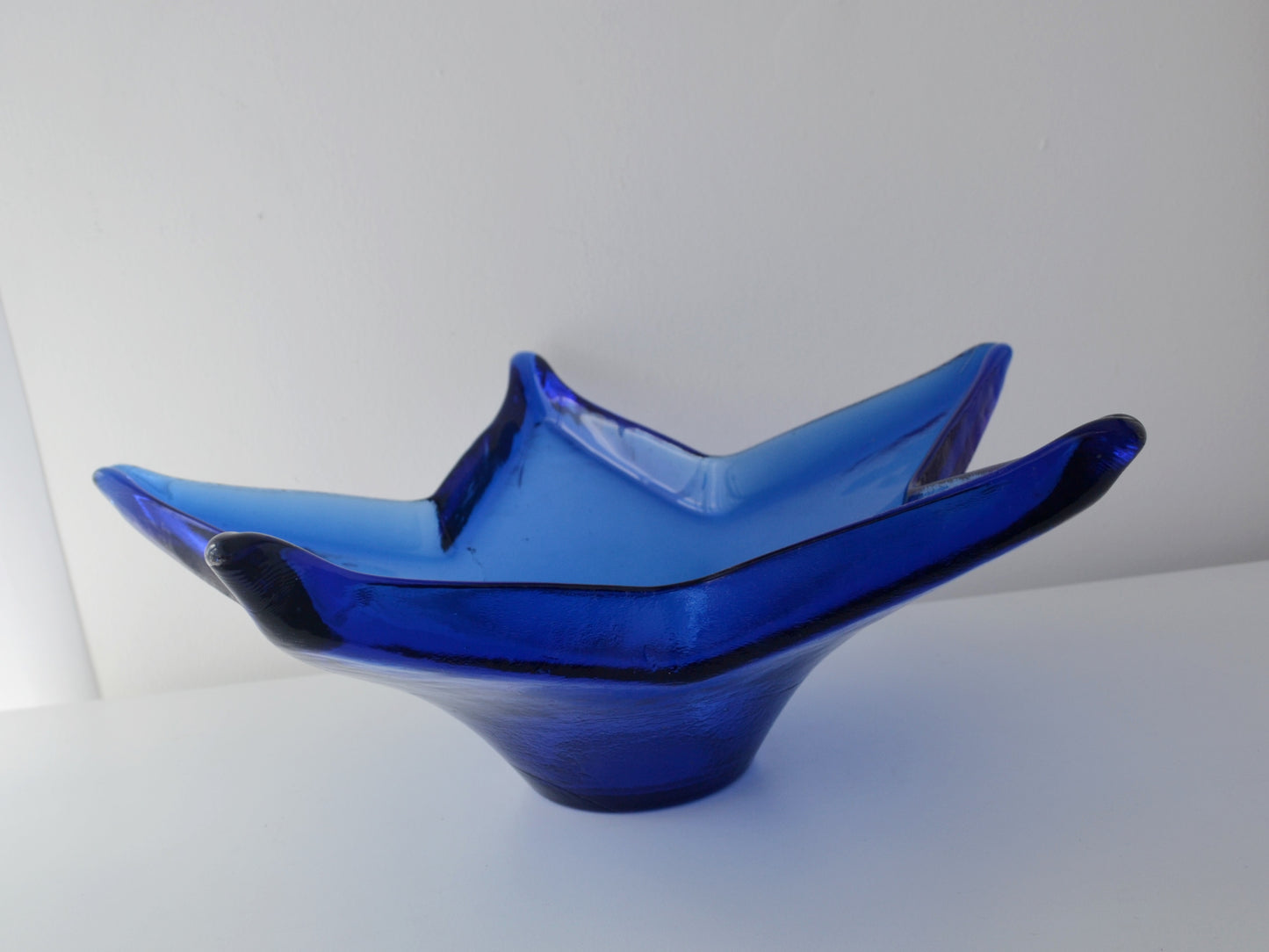 Side profile of cobalt blue pressed glass bowl, HSG Ząbkowice Poland, circa 1970s, showing footed base.