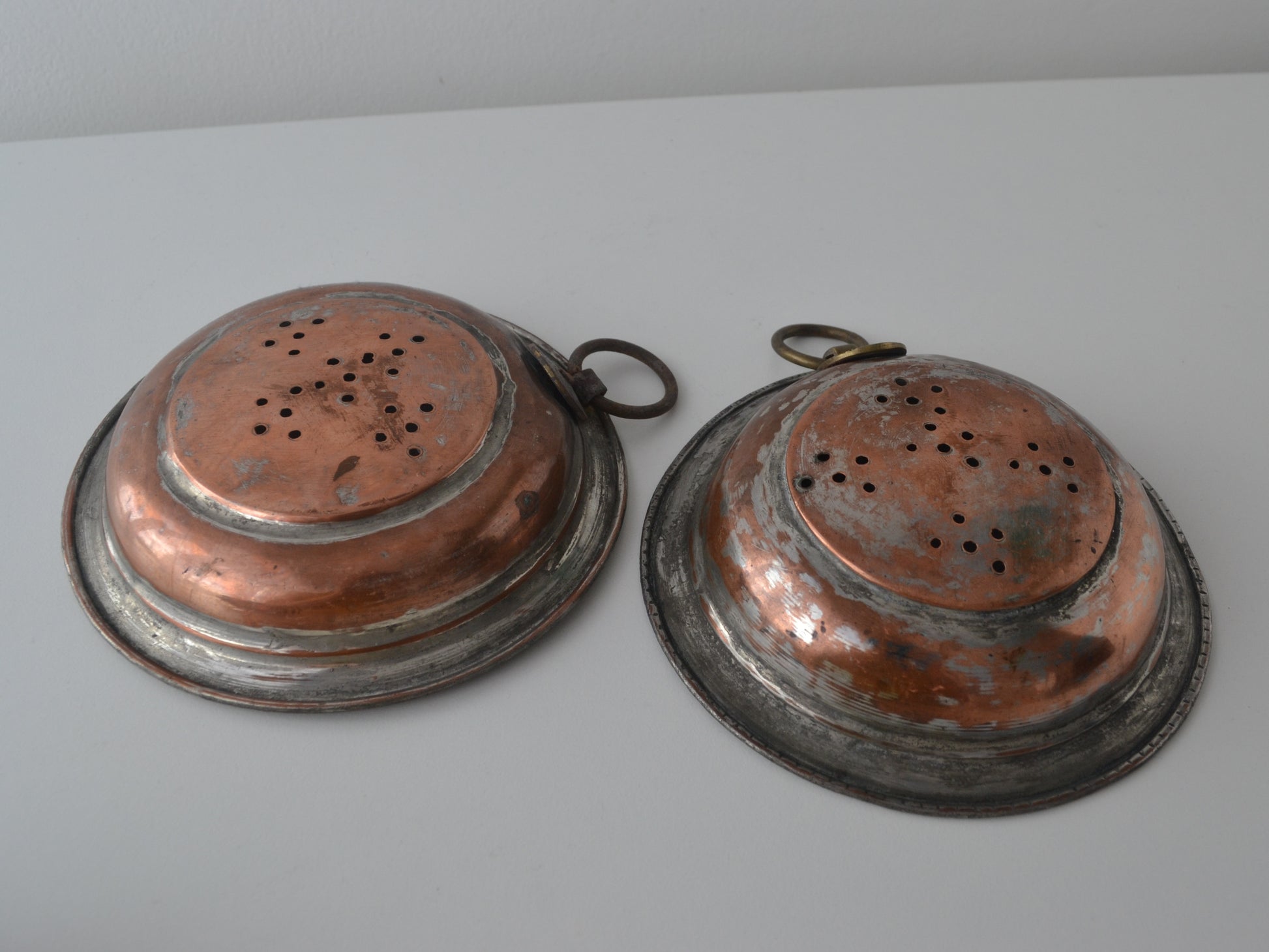 Side profile of antique French copper colander, 19th century, showing hammer marks and natural patina.