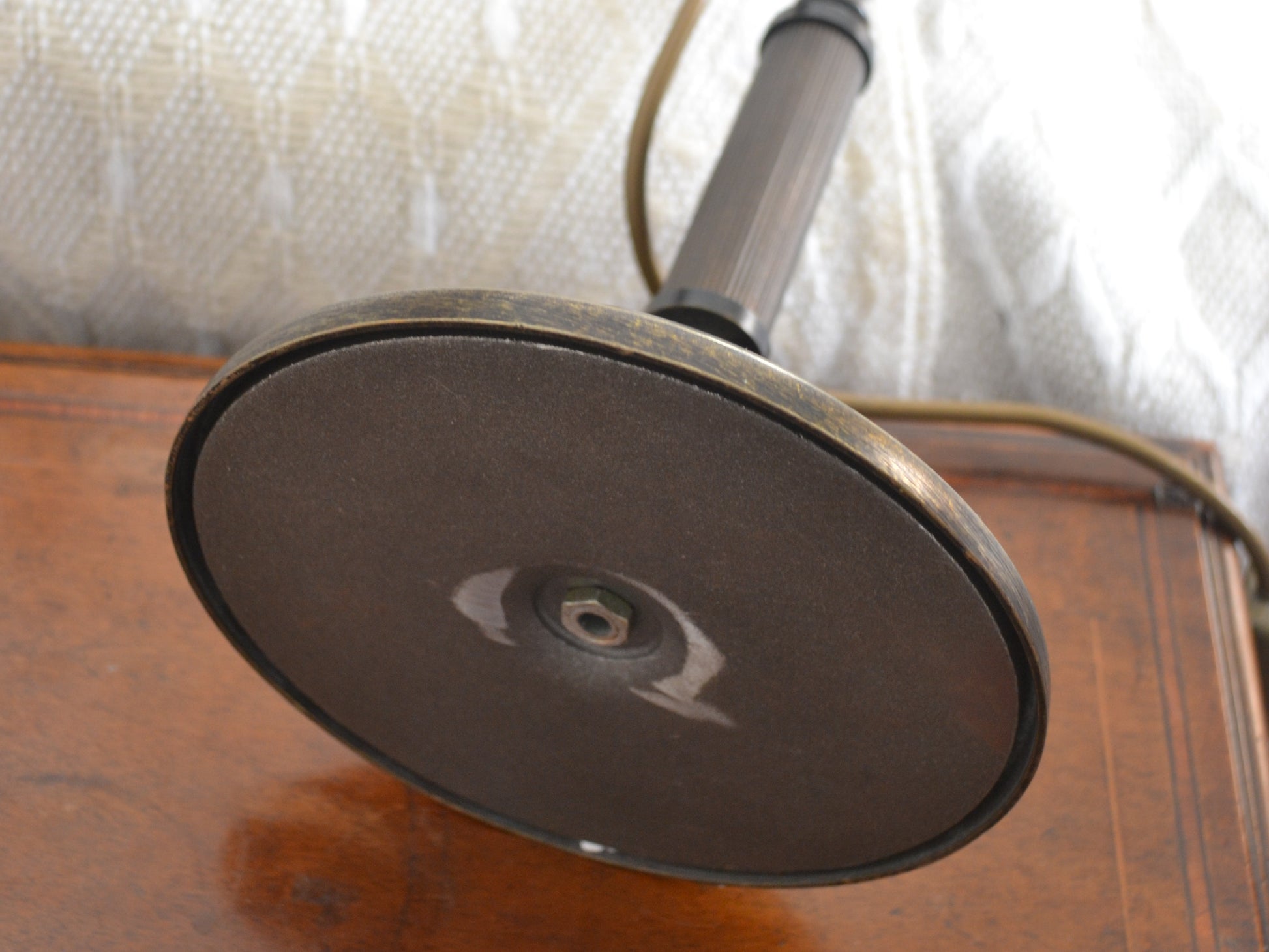 Underside of brass table lamp base, no maker's mark visible.