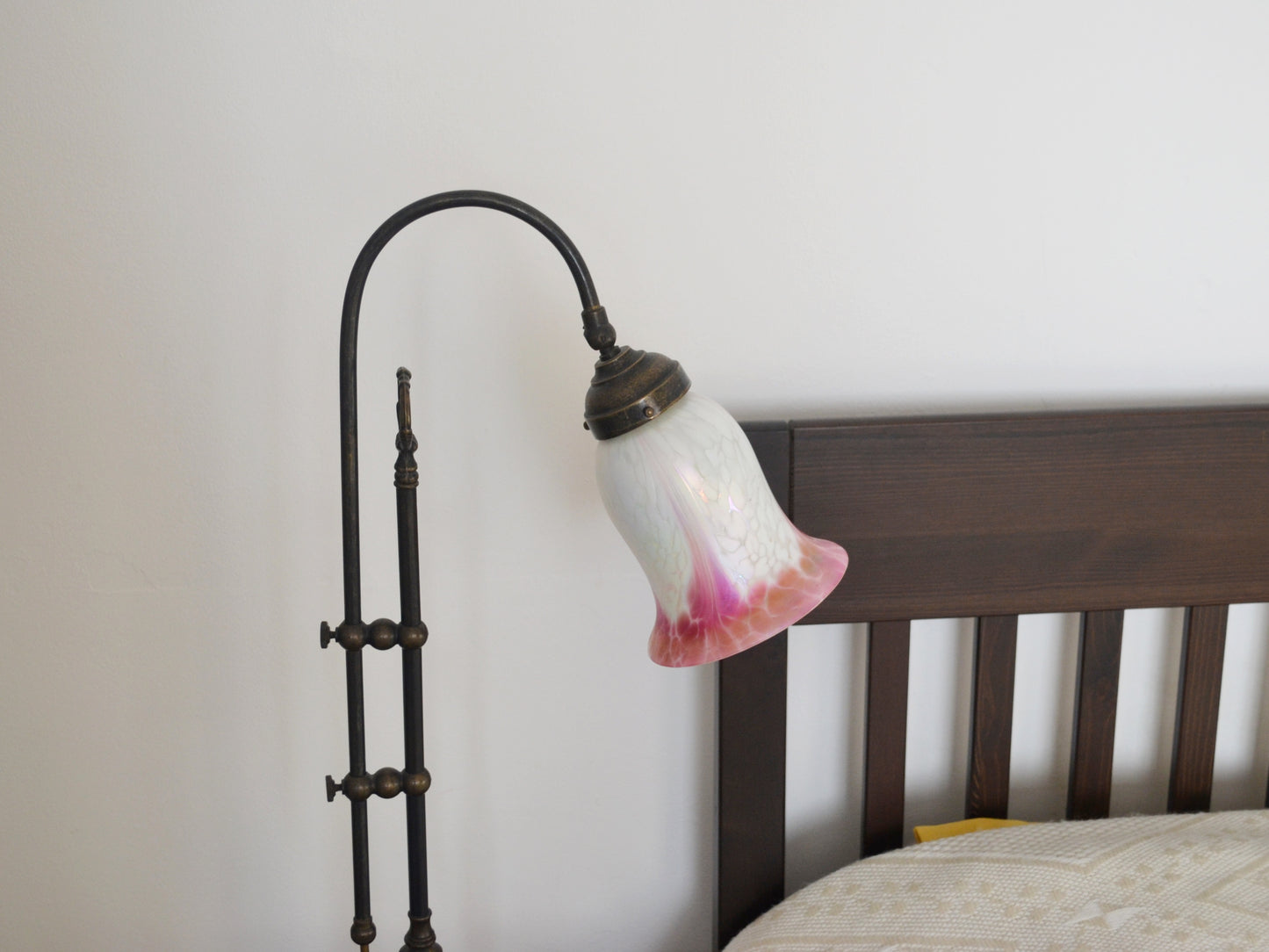 Detail of hand-blown opaline glass tulip shade, white with deep pink gradient and iridescent surface, brass fitting.