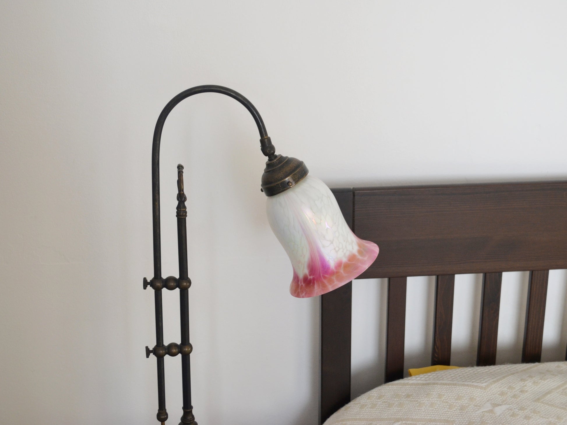 Detail of hand-blown opaline glass tulip shade, white with deep pink gradient and iridescent surface, brass fitting.