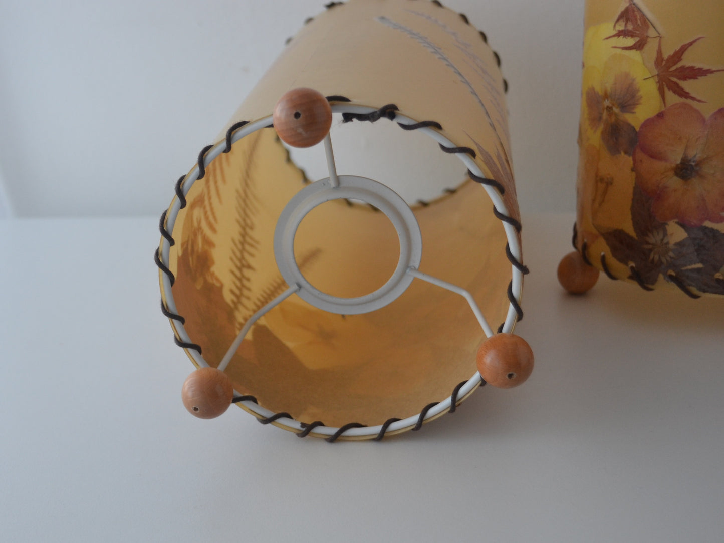Metal spider ring fitting with wooden ball feet, pressed flower parchment lampshade, circa 1970s.