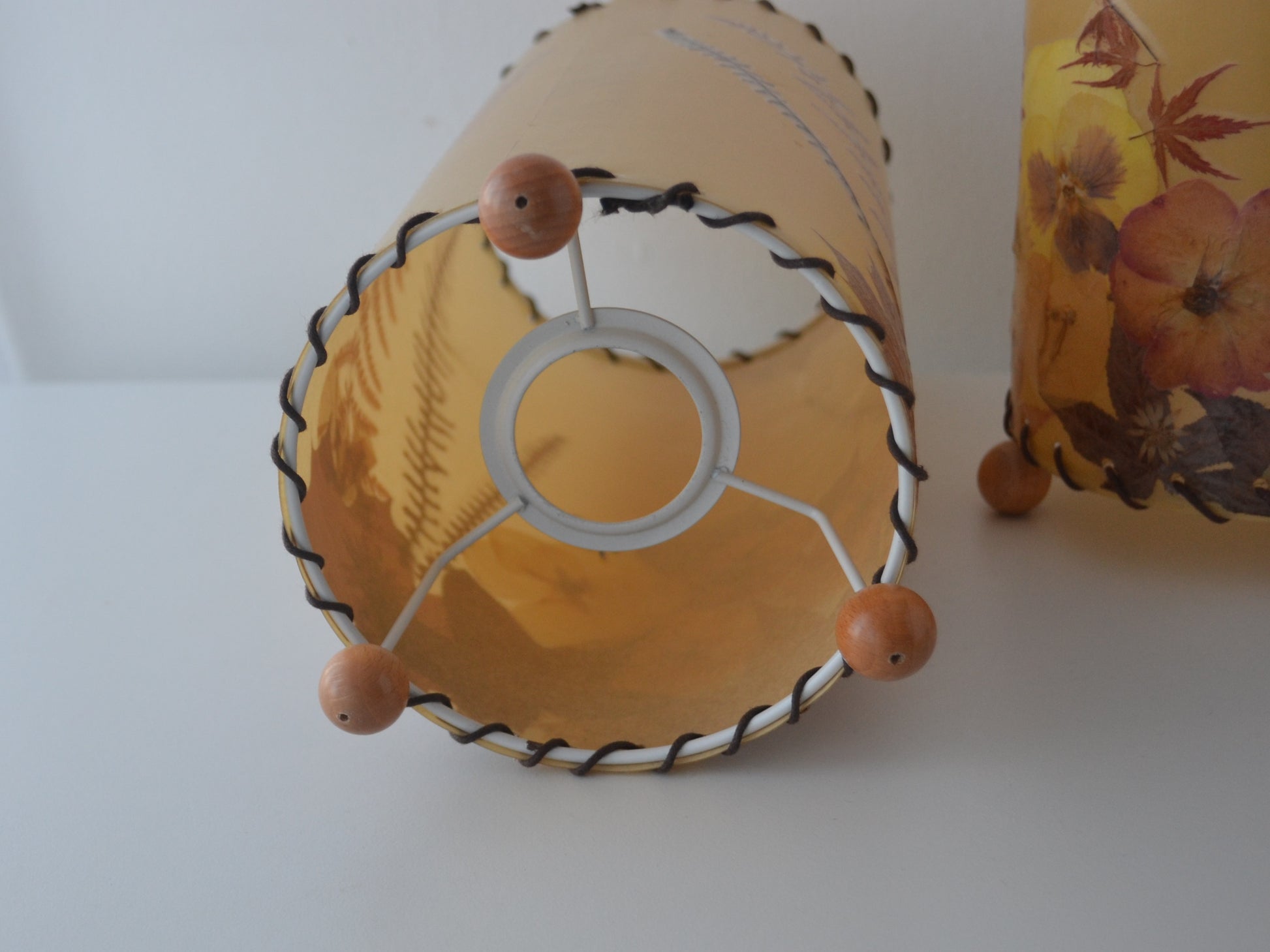 Metal spider ring fitting with wooden ball feet, pressed flower parchment lampshade, circa 1970s.