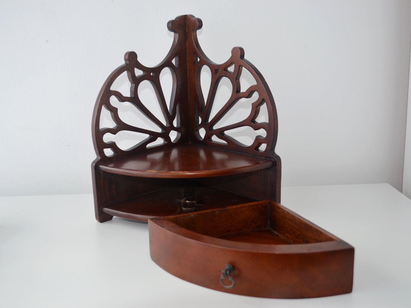 Mahogany Georgian corner shelf showing triangular platform, pierced fretwork tracery and brass drawer pull, front view, circa 1800s