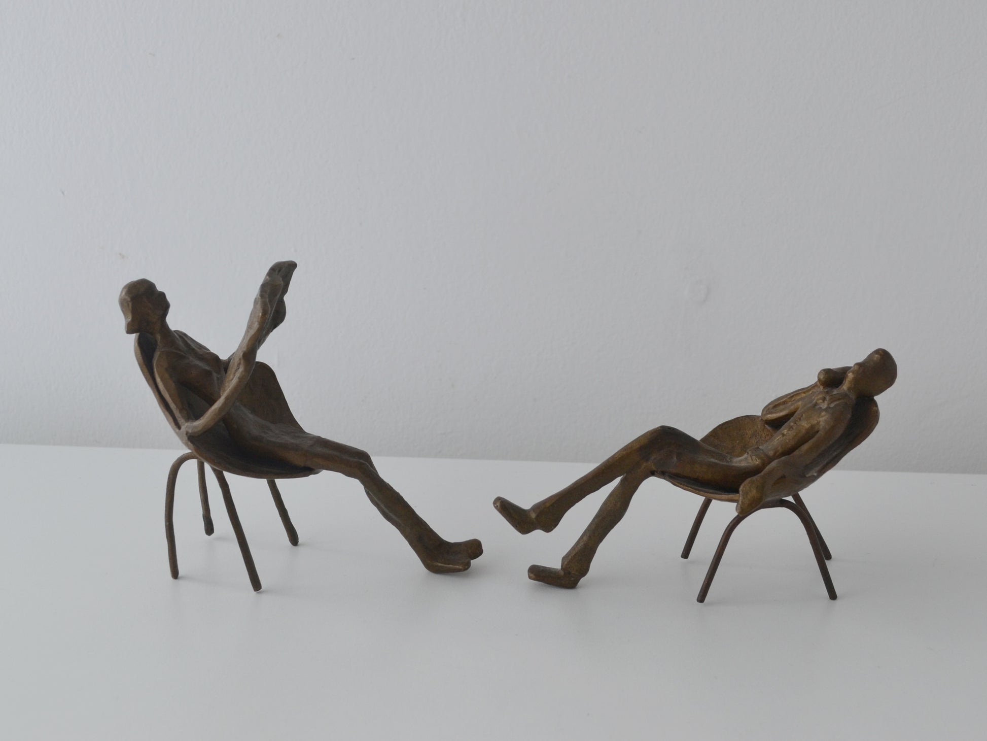 Bronze figural sculpture pair, waiting room scene, side view showing tulip chair frames and wire legs, circa 1960s