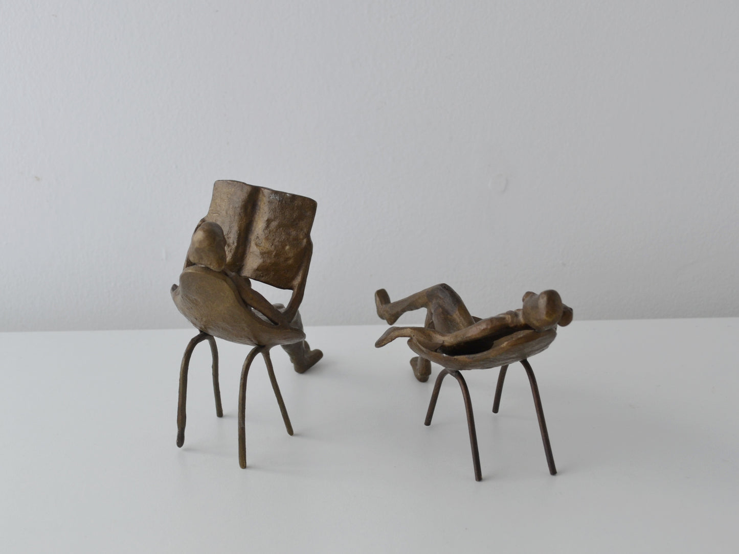 Mid-Century Modern bronze sculpture pair, woman with newspaper and man with telephone receiver, three-quarter rear view, circa 1960s
