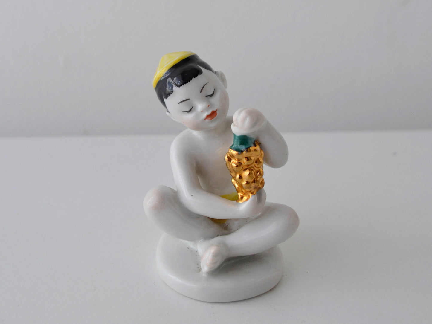 Soviet LFZ porcelain figurine, Uzbek boy with golden grapes, USSR circa 1960s, front view.
