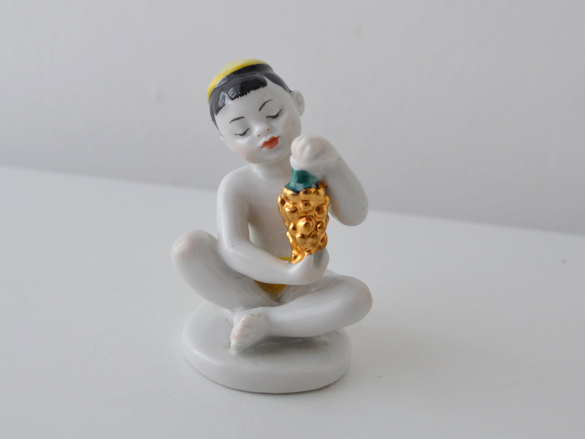 Gilt grape detail on Soviet LFZ porcelain boy figurine, circa 1960s.