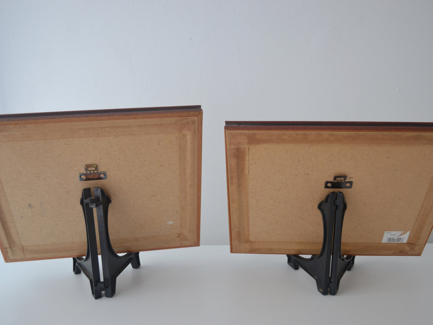 Reverse of vintage framed L.S. Lowry prints showing picture hanger hardware.