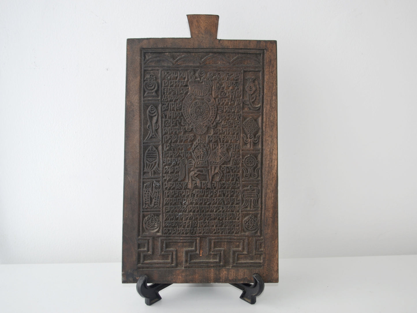 Tibetan Buddhist hardwood woodblock, Uchen script and Ashtamangala carving, circa 19th century, front view on display stand