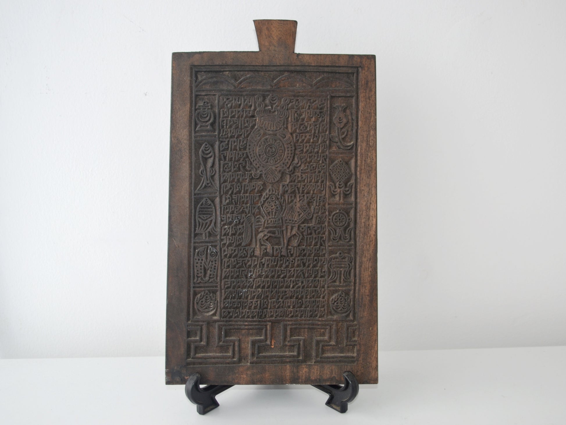 Tibetan Buddhist hardwood woodblock, Uchen script and Ashtamangala carving, circa 19th century, front view on display stand