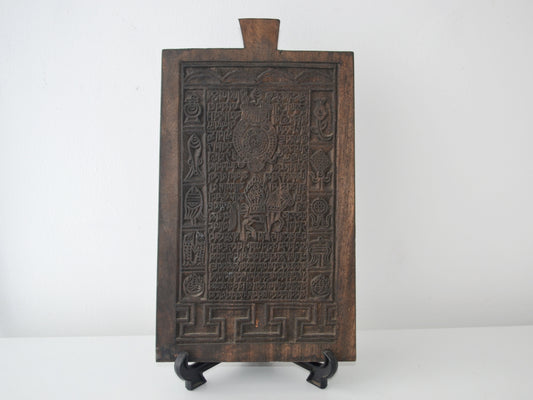 Tibetan Buddhist hardwood woodblock, Uchen script and Ashtamangala carving, circa 19th century, front view on display stand