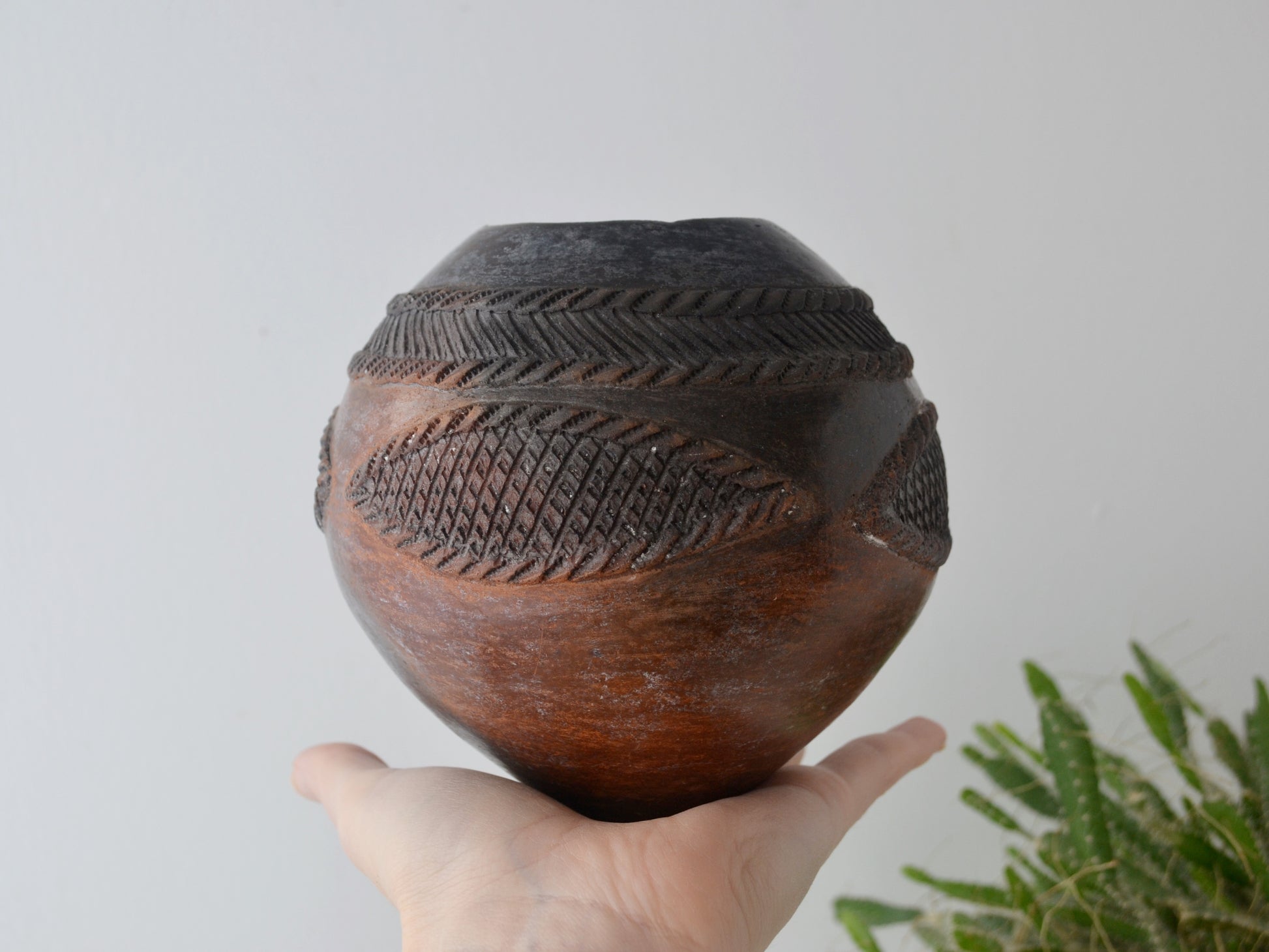 Zulu ukhamba by Mfeka, ombre smoke-fired surface graduating from charcoal to terracotta, side angle view