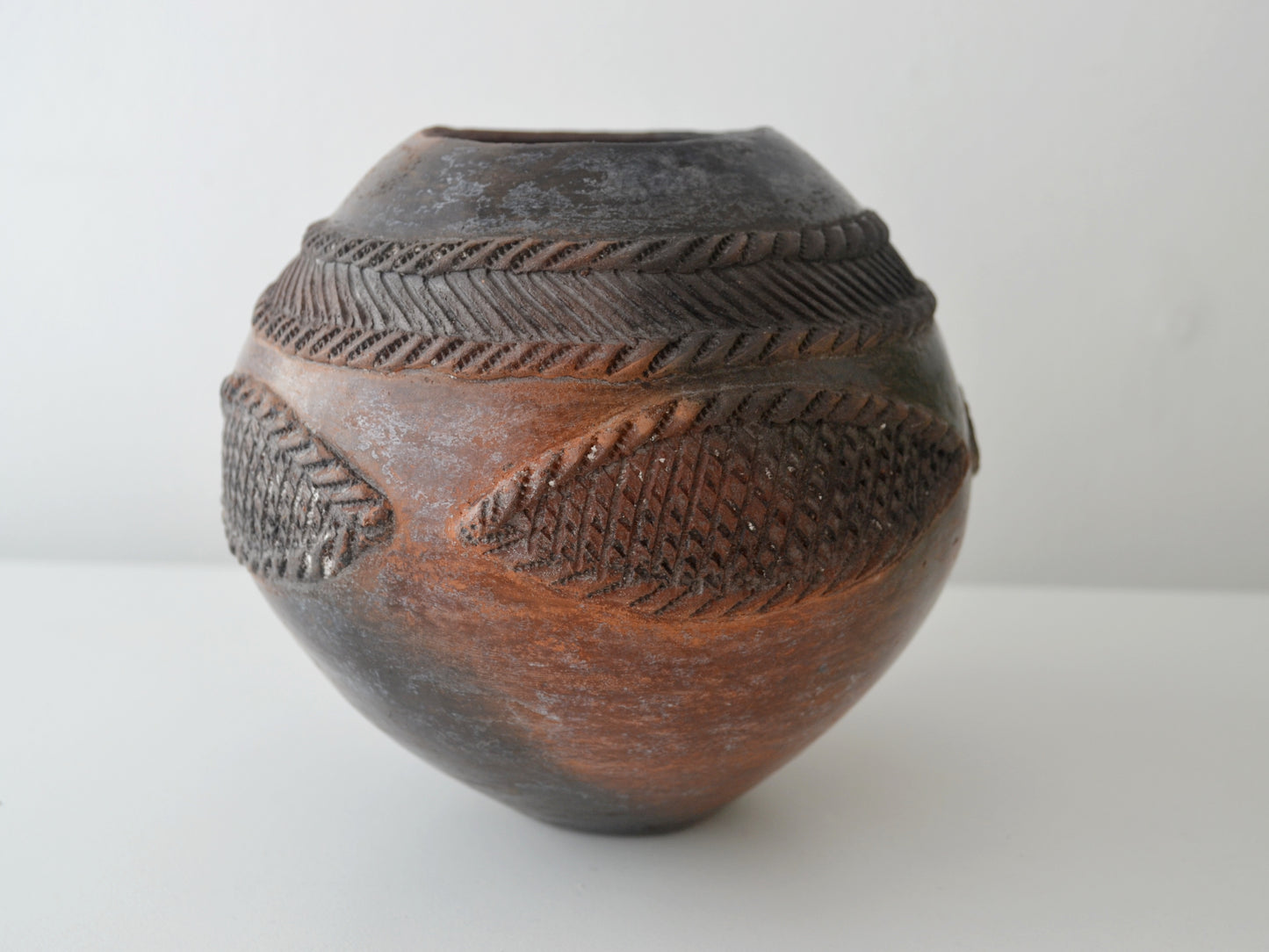 Signed Zulu ukhamba vessel by Mfeka, hand-coiled smoke-fired earthenware, incised geometric decoration, KwaZulu-Natal South Africa, front view
