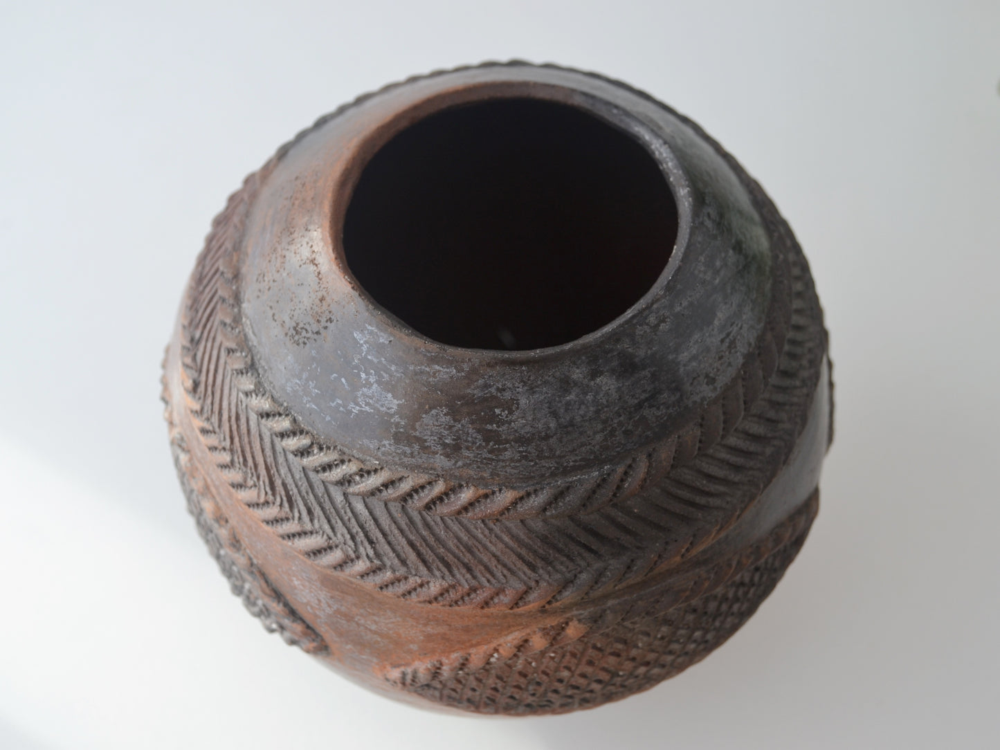 Signed Zulu ukhamba vessel by Mfeka in styled interior setting with foliage, smoke-fired earthenware South Africa