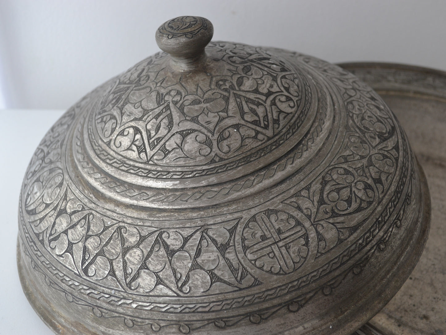 Detail of domed cover of Persian tinned copper sahan showing dense arabesque and palmette engraving, Qajar tradition circa 19th century