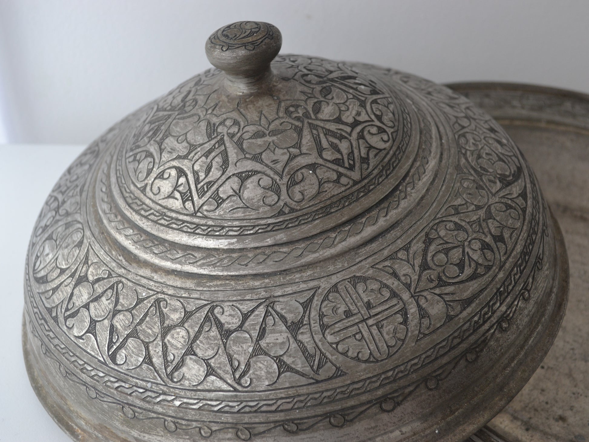 Detail of domed cover of Persian tinned copper sahan showing dense arabesque and palmette engraving, Qajar tradition circa 19th century