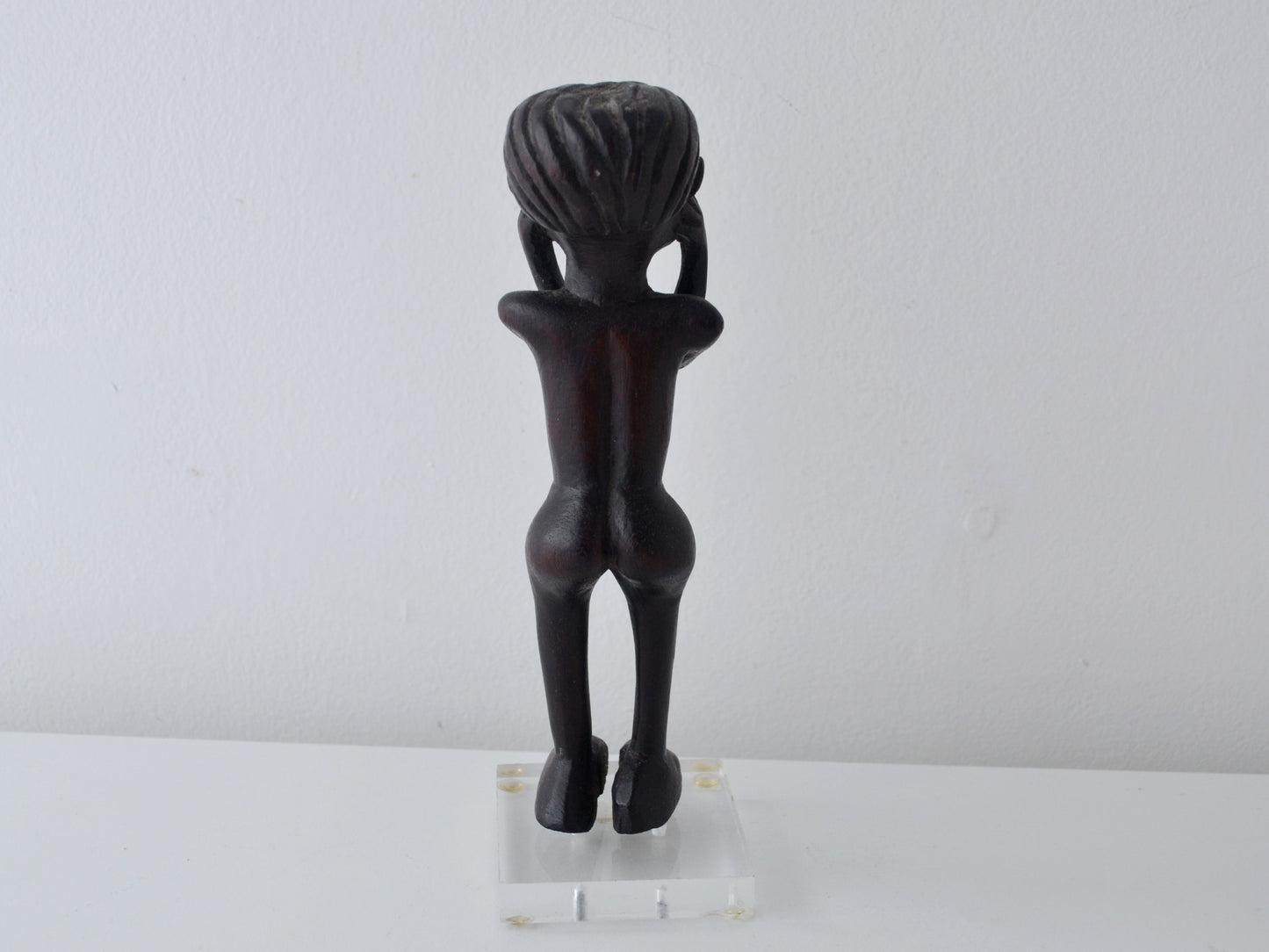 Hand-carved African hardwood standing figure, Makonde tradition, full frontal view showing disc headdress and raised hands, circa mid-20th century